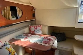Slide: The Image of 2007 Sea Ray 290 Amberjack boat interior with white seating and blue canopy. - 8