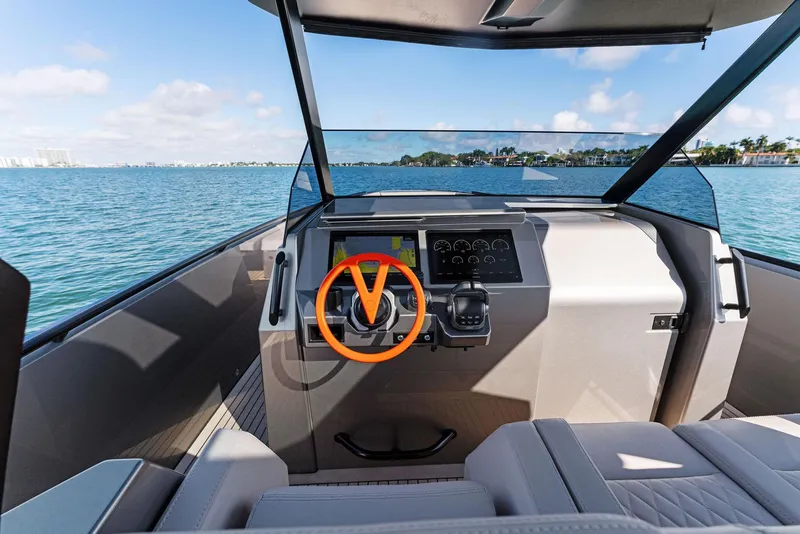 Slide: The Image of 2022 Vanquish Yachts VQ40 helm with modern dashboard and scenic water view. - 39
