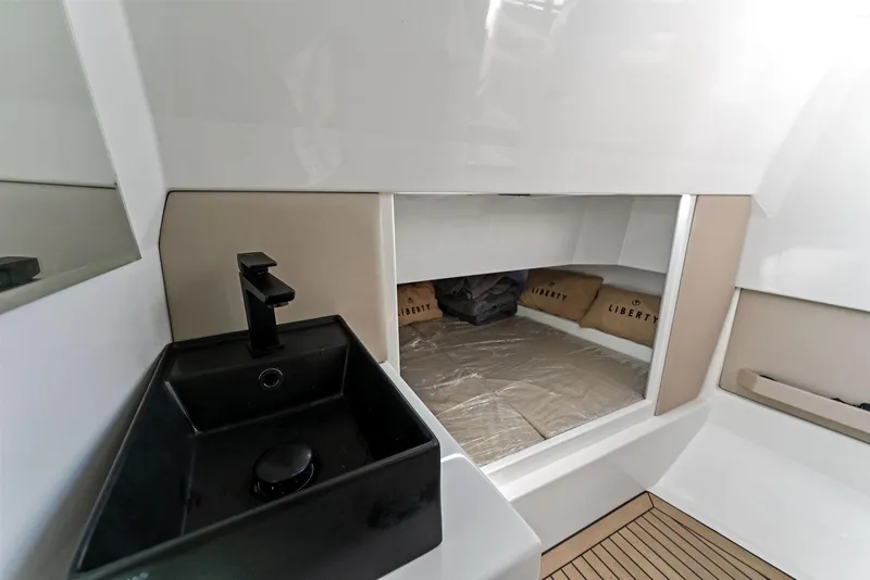 Slide: The Image of Interior of 2022 Vanquish Yachts VQ40, featuring a sleek black sink and cozy cabin space. - 48