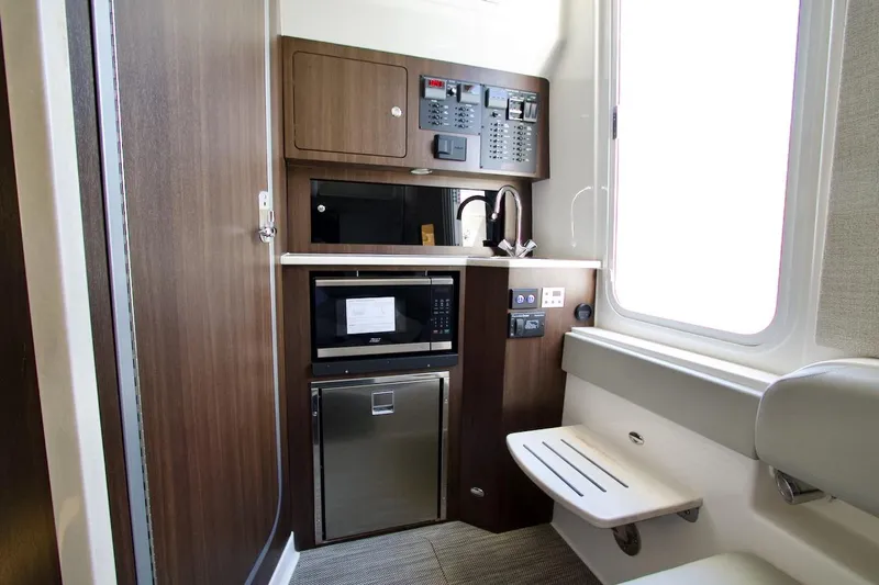 Slide: The Image of 2026 Regulator 37 boat interior with kitchenette, featuring microwave, sink, and control panel. - 16