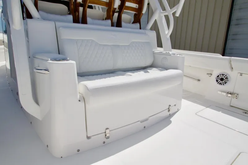 Slide: The Image of Luxurious seating on 2026 Regulator 37 boat, featuring white upholstery and cup holders. - 2