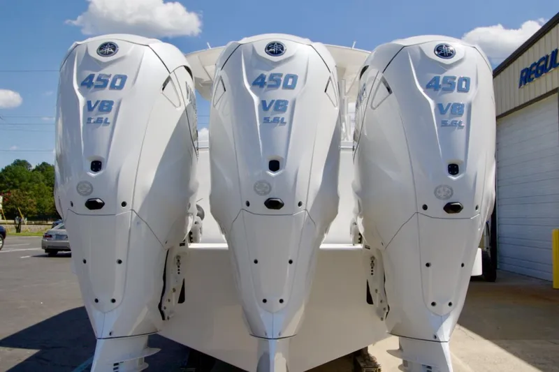 Slide: The Image of Triple 450 V8 outboard engines on a 2026 Regulator 37 boat, parked outdoors. - 22