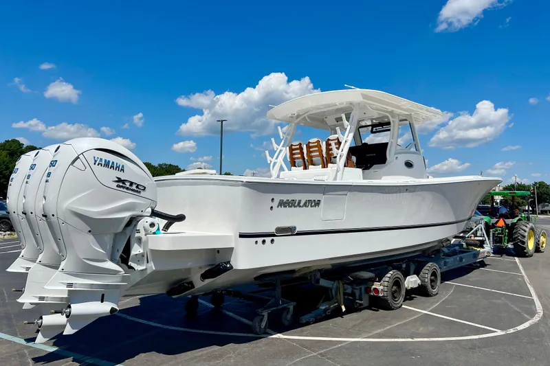 Slide: The Image of 2026 Regulator 37 boat with Yamaha engines on a trailer under a clear blue sky. - 24