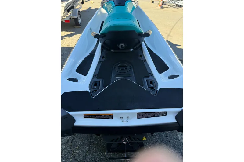 Slide: The Image of 2021 Seadoo GTI90 jet ski, rear view, teal seat, parked on pavement. - 10