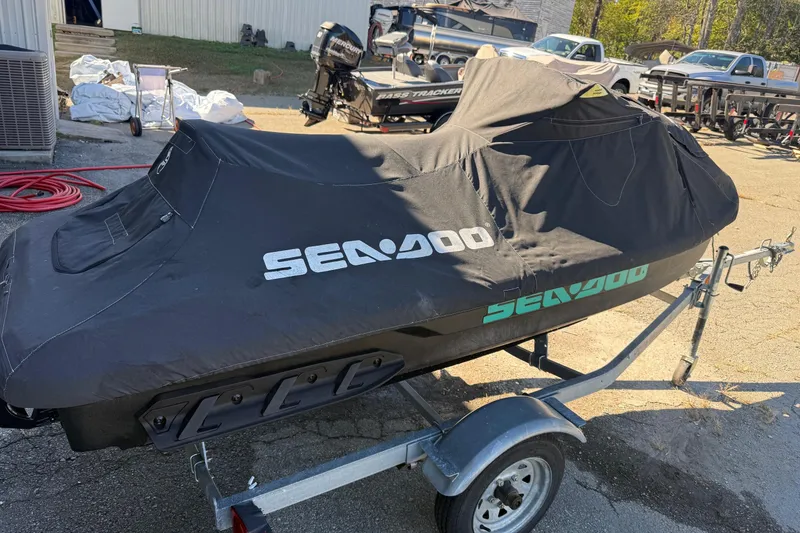 Slide: The Image of 2021 Seadoo GTI90 jet ski covered on a trailer in a parking lot. - 28