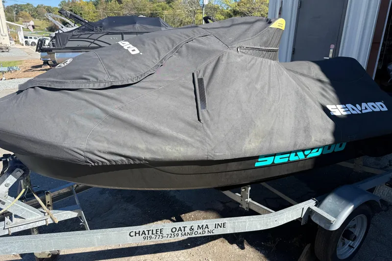 Slide: The Image of 2021 Seadoo GTI90 jet ski covered on trailer, outdoor setting. - 30