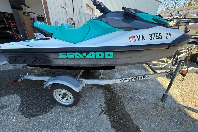 Slide: The Image of 2021 Seadoo GTI90 jet ski on trailer, teal and white design, parked outdoors. - 6
