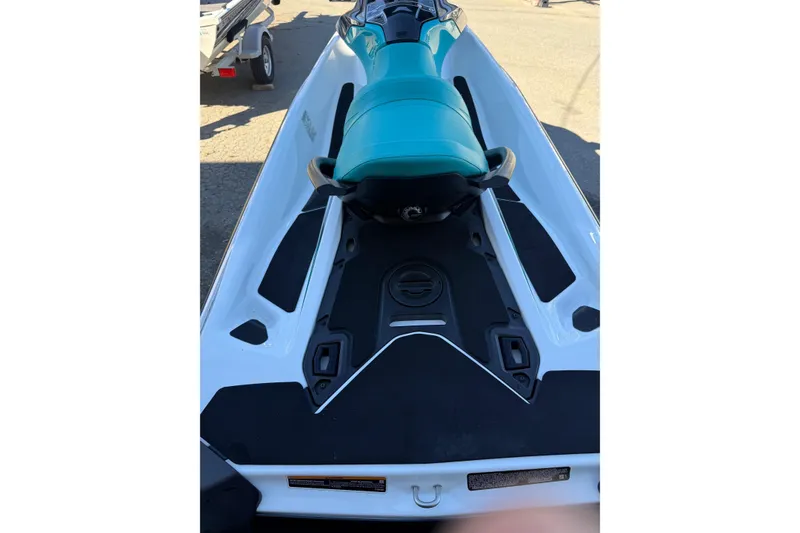 Slide: The Image of 2021 Seadoo GTI90 jet ski with teal seat, parked on pavement. - 9