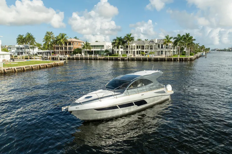 Slide: The Image of Luxury Valiatt 410HT yacht cruising near waterfront homes, 2025 model. - 25