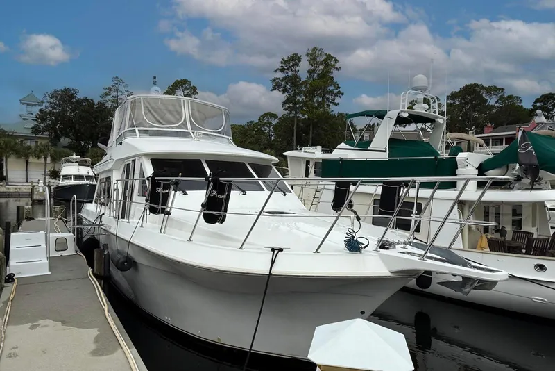 Slide: The Image of 2004 Navigator 4800 yacht docked at marina under cloudy sky. - 1
