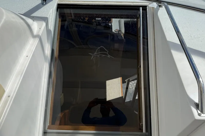 Slide: The Image of Glass hatch on 2004 Navigator 4800 yacht, reflecting sunlight and interior details. - 14