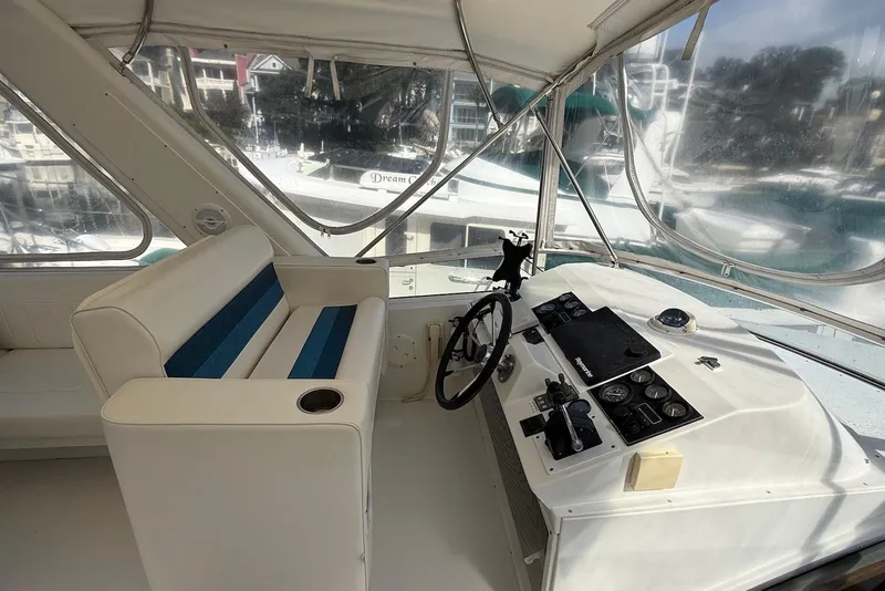 Slide: The Image of 2004 Navigator 4800 yacht helm with white seating and control panel. - 15
