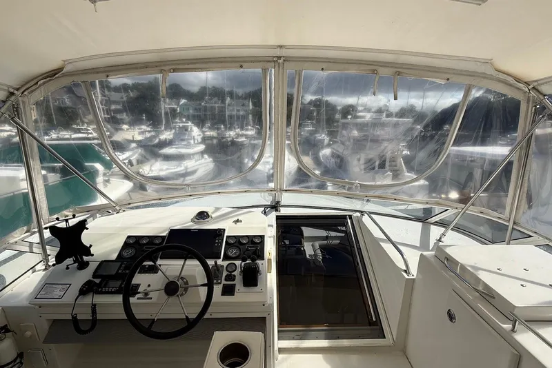Slide: The Image of Interior view of 2004 Navigator 4800 yacht helm with marina in background. - 16