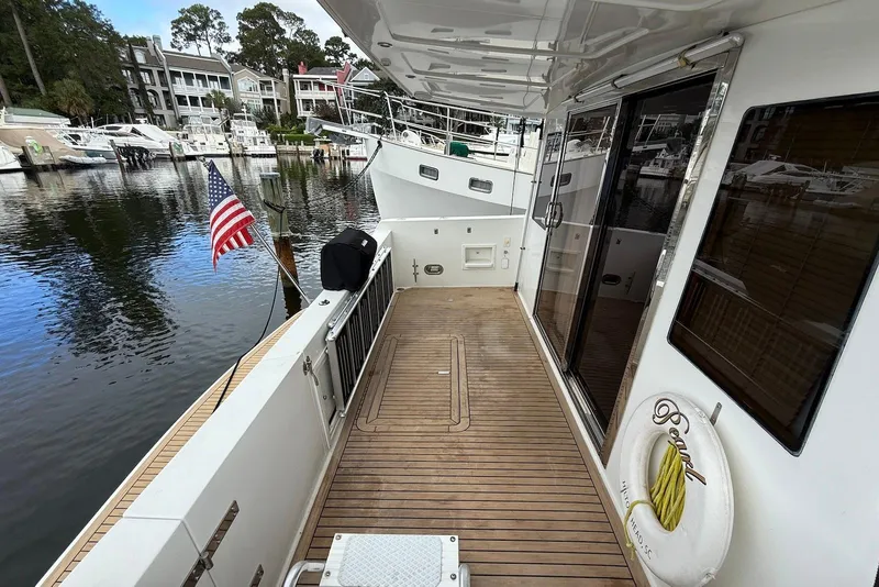 Slide: The Image of 2004 Navigator 4800 yacht deck with American flag, docked in a marina. - 18