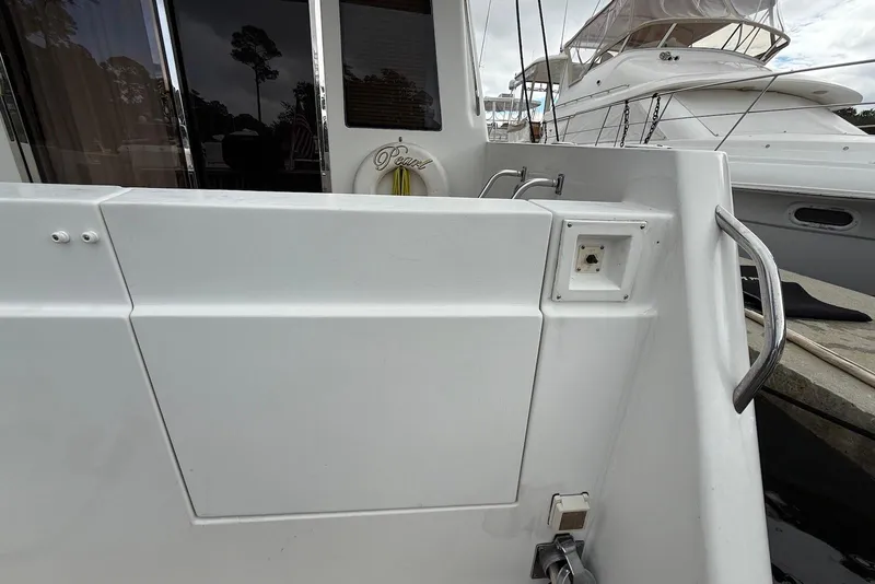 Slide: The Image of 2004 Navigator 4800 yacht deck with railing and docked boat in background. - 21