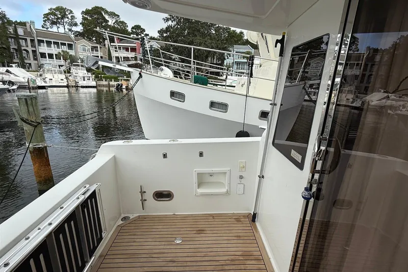 Slide: The Image of 2004 Navigator 4800 yacht docked at marina, featuring spacious deck and modern design. - 23