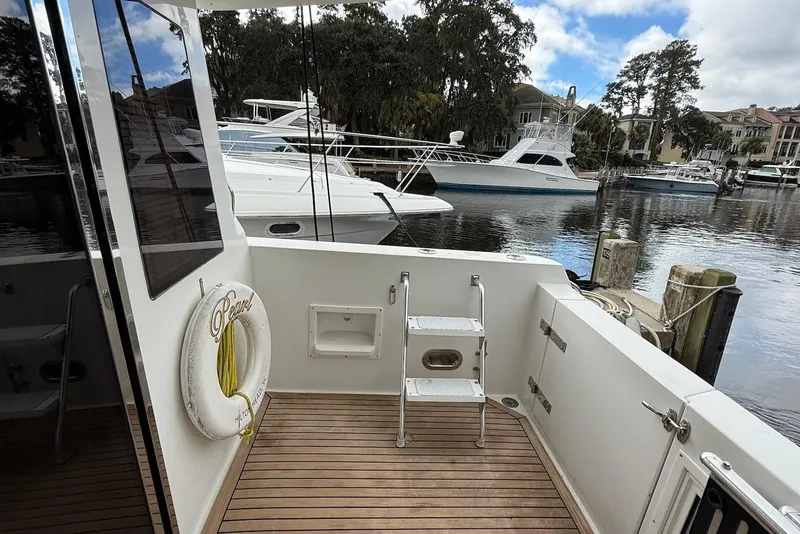 Slide: The Image of 2004 Navigator 4800 yacht deck with ladder, docked at marina with other boats. - 24