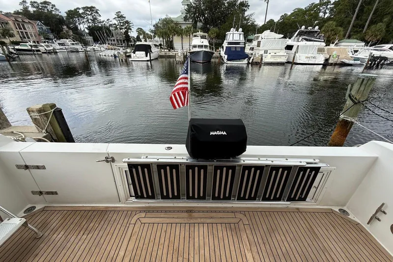 Slide: The Image of Deck view of a 2004 Navigator 4800 yacht in a marina with boats. - 25