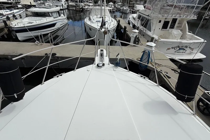 Slide: The Image of Bow view of 2004 Navigator 4800 yacht docked at marina with surrounding boats. - 27