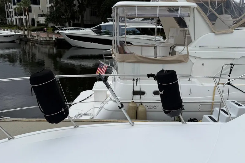 Slide: The Image of 2004 Navigator 4800 yacht docked with protective fenders, surrounded by other boats. - 30