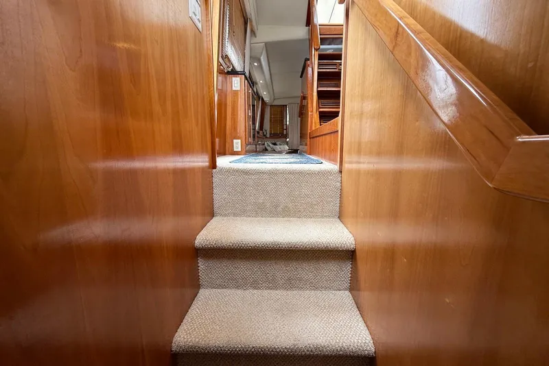 Slide: The Image of Carpeted stairs inside 2004 Navigator 4800 yacht with wooden paneling. - 34
