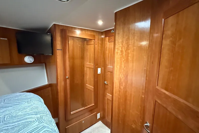 Slide: The Image of 2004 Navigator 4800 yacht interior with wood paneling, TV, and cozy bedroom. - 38