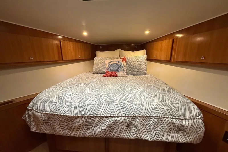 Slide: The Image of Cozy bedroom in 2004 Navigator 4800 yacht with patterned bedding and wooden cabinets. - 41