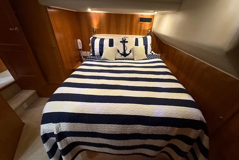 Slide: The Image of Luxurious 2004 Navigator 4800 yacht bedroom with nautical-themed bedding. - 47