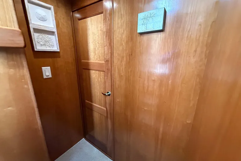 Slide: The Image of Wood-paneled hallway in 2004 Navigator 4800 yacht with decorative wall art and door. - 48