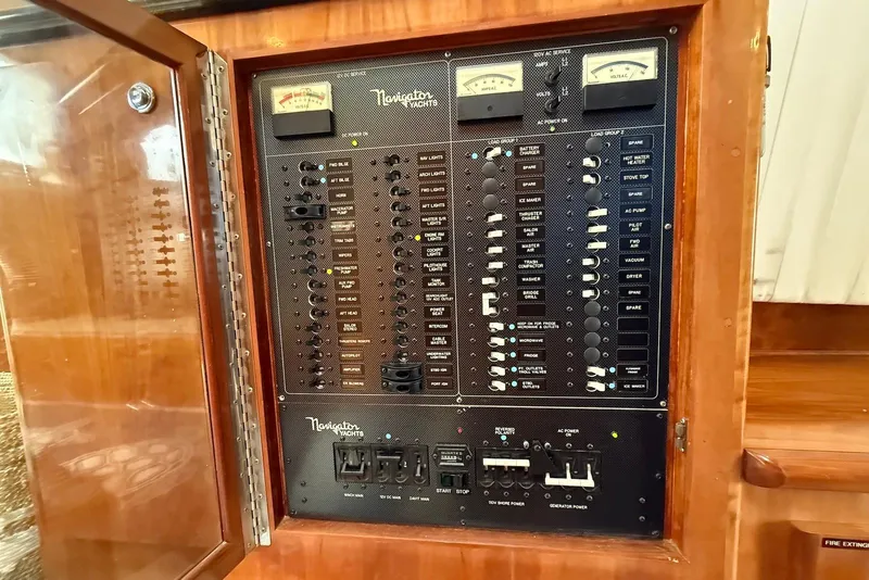 Slide: The Image of Electrical control panel on a 2004 Navigator 4800 yacht, featuring various switches and gauges. - 60