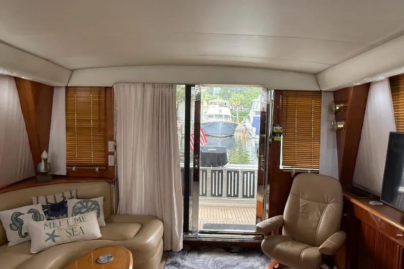 Slide: The Image of Interior of 2004 Navigator 4800 yacht with cozy seating and marina view. - 68
