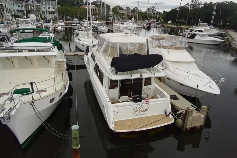 Slide: The Image of 2004 Navigator 4800 yacht docked at marina, surrounded by other boats. - 8