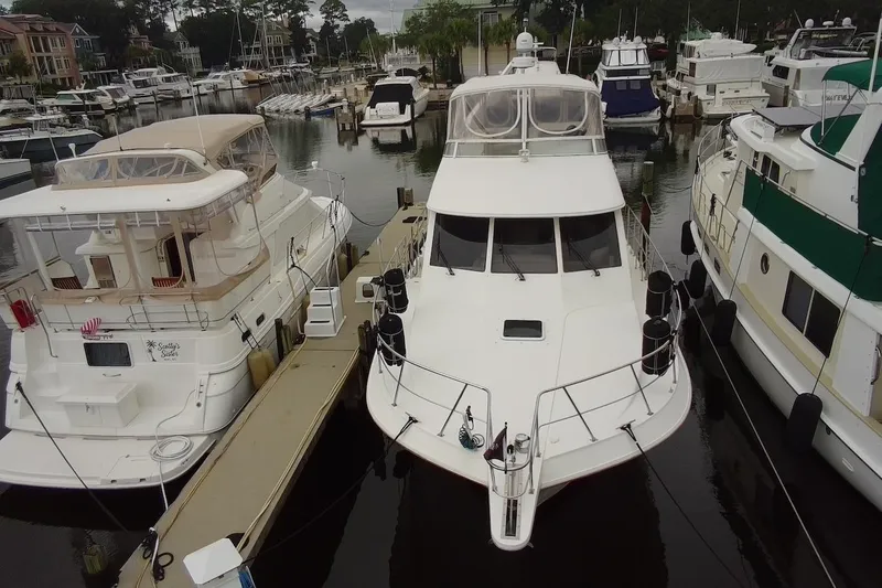 Slide: The Image of 2004 Navigator 4800 yacht docked at marina, surrounded by other boats. - 9