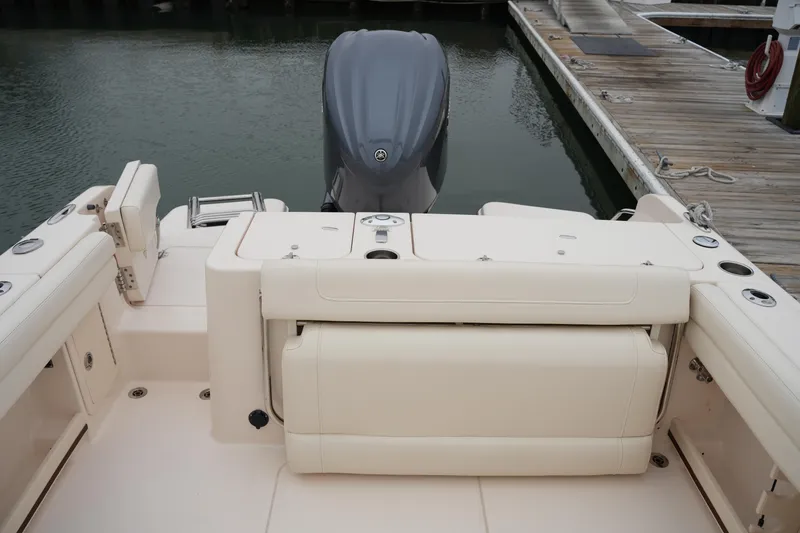 Slide: The Image of 2022 Grady-White Freedom 235 boat interior with seating and engine view at dock. - 19