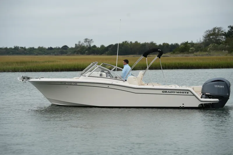 Slide: The Image of 2022 Grady-White Freedom 235 boat on calm water with scenic background. - 2