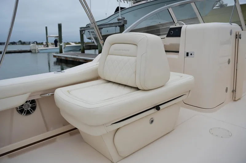 Slide: The Image of 2022 Grady-White Freedom 235 boat interior with luxurious seating at a marina. - 21