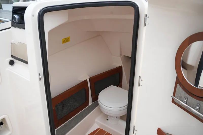 Slide: The Image of 2022 Grady-White Freedom 235 boat interior with compact marine toilet. - 32