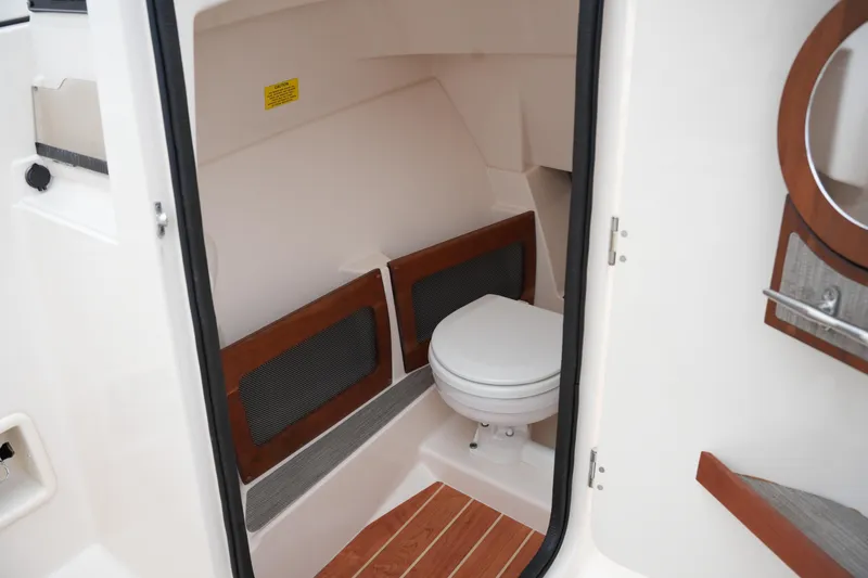 Slide: The Image of 2022 Grady-White Freedom 235 boat interior with compact marine toilet. - 34