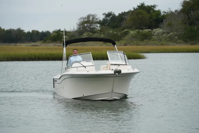 Slide: The Image of 2022 Grady-White Freedom 235 boat cruising on a calm waterway. - 6