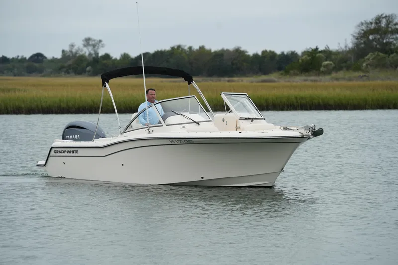 Slide: The Image of 2022 Grady-White Freedom 235 boat cruising on a calm river. - 8