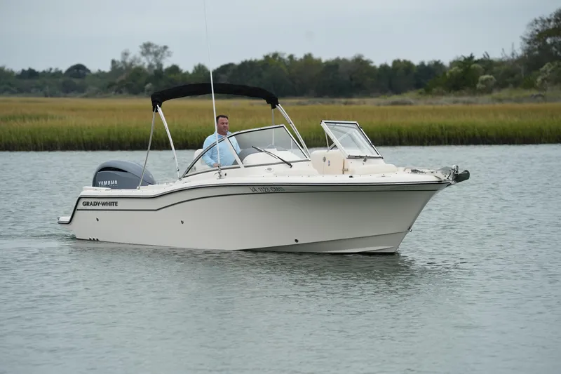 Slide: The Image of 2022 Grady-White Freedom 235 boat cruising on a calm river. - 9