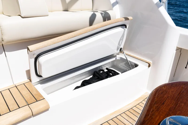 Slide: The Image of Open storage compartment on 2021 Viking 44 Open yacht, featuring teak accents and marine rope. - 19
