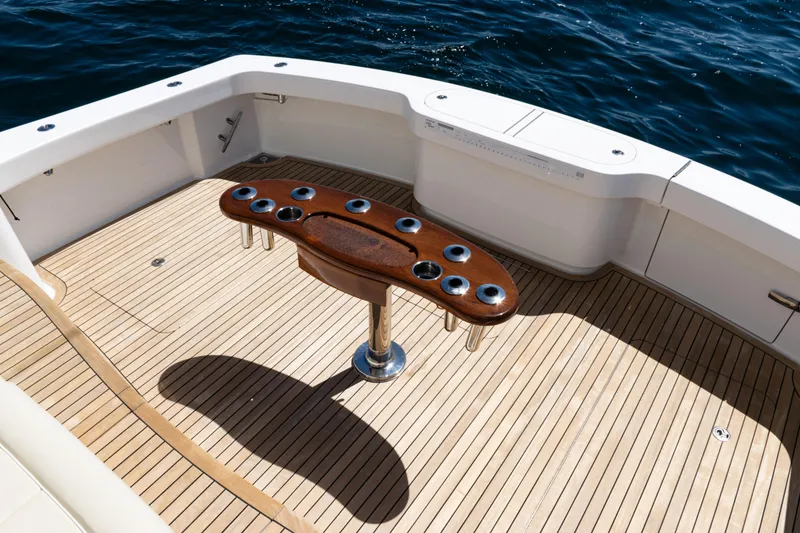 Slide: The Image of 2021 Viking 44 Open yacht deck with wooden table, surrounded by ocean water. - 23
