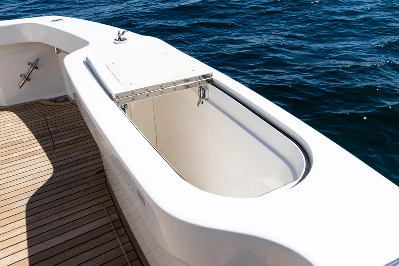 Slide: The Image of 2021 Viking 44 Open yacht deck with open storage compartment, on calm blue water. - 28