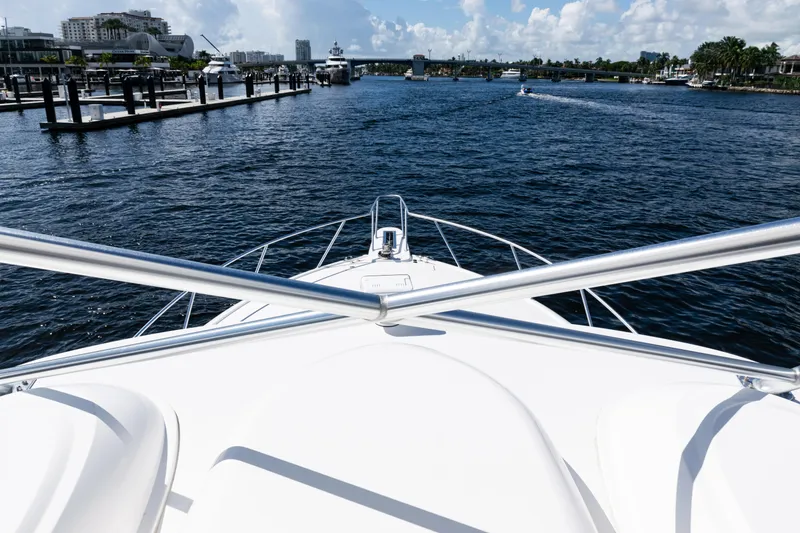 Slide: The Image of Bow view of 2021 Viking 44 Open yacht navigating a marina. - 44