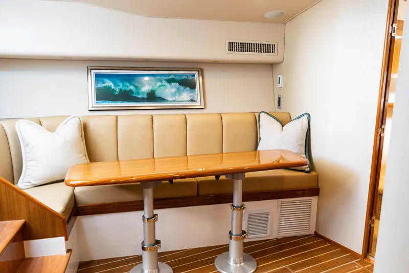 Slide: The Image of 2021 Viking 44 Open yacht interior with elegant seating and wooden table. - 70