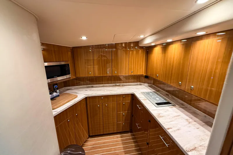 Slide: The Image of Luxurious kitchen interior of 2021 Viking 44 Open yacht with wood cabinetry and modern appliances. - 71