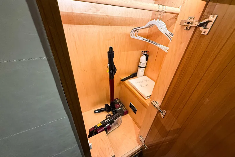 Slide: The Image of Wooden closet in 2021 Viking 44 Open yacht with hangers, vacuum, and fire extinguisher. - 82