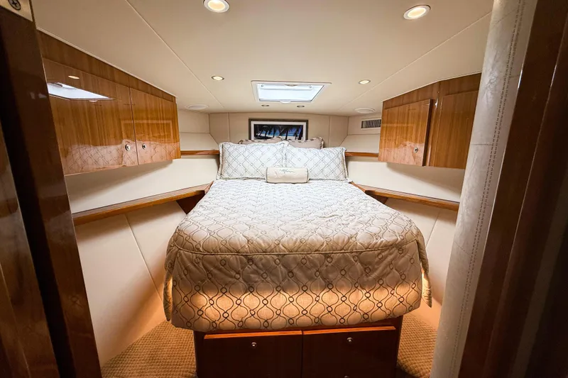 Slide: The Image of Luxurious cabin interior of 2021 Viking 44 Open yacht with elegant bedding and wood cabinetry. - 83