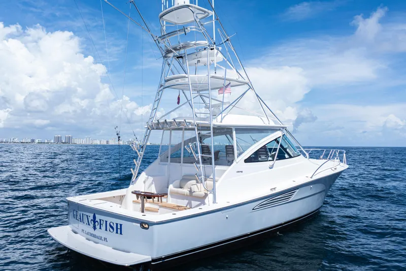 Slide: The Image of 2021 Viking 44 Open yacht on ocean, clear sky, city skyline in background. - 97